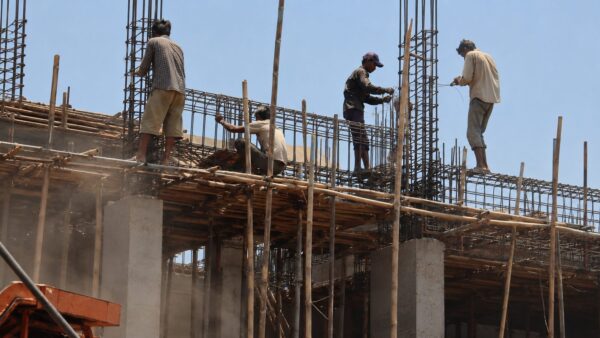 東南アジアの建設現場、ヘルメットも安全帯も付けずに高所で危険な姿勢で鉄筋を組む作業員